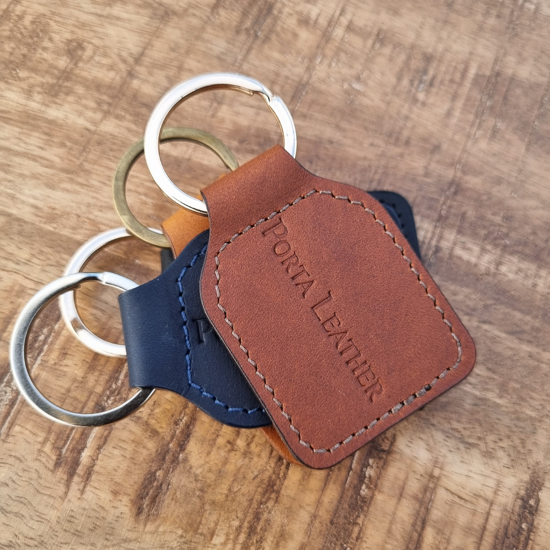 Porta Leather Tag Keyring in Heritage Brown made in Australia from Australian Leather. Other colours are also pictured stacked in the background.