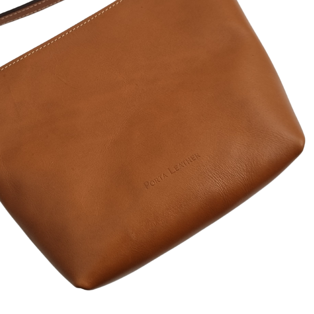 Close up view of the Porta Leather Ava Crossbody Bag in Tan with Gold hardware