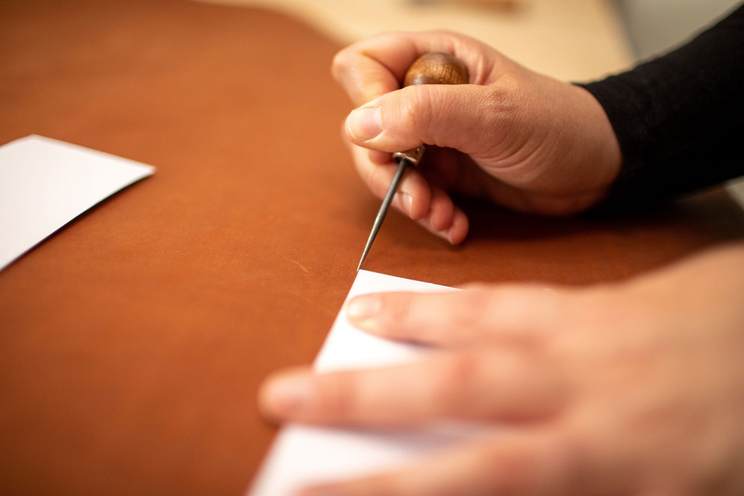 Marking out leather pattern with an awl for handmade leather goods.