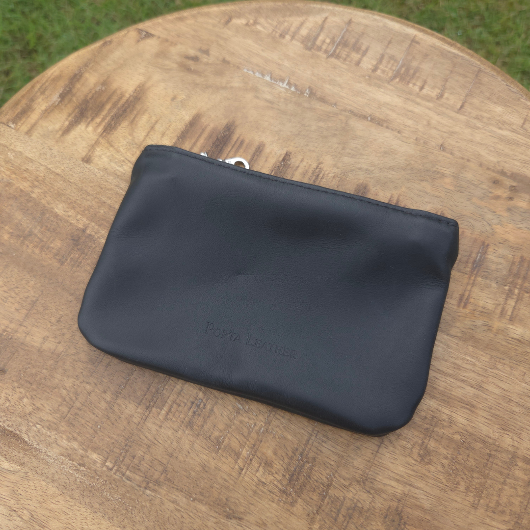 Black Porta Leather mini pouch placed on a stool