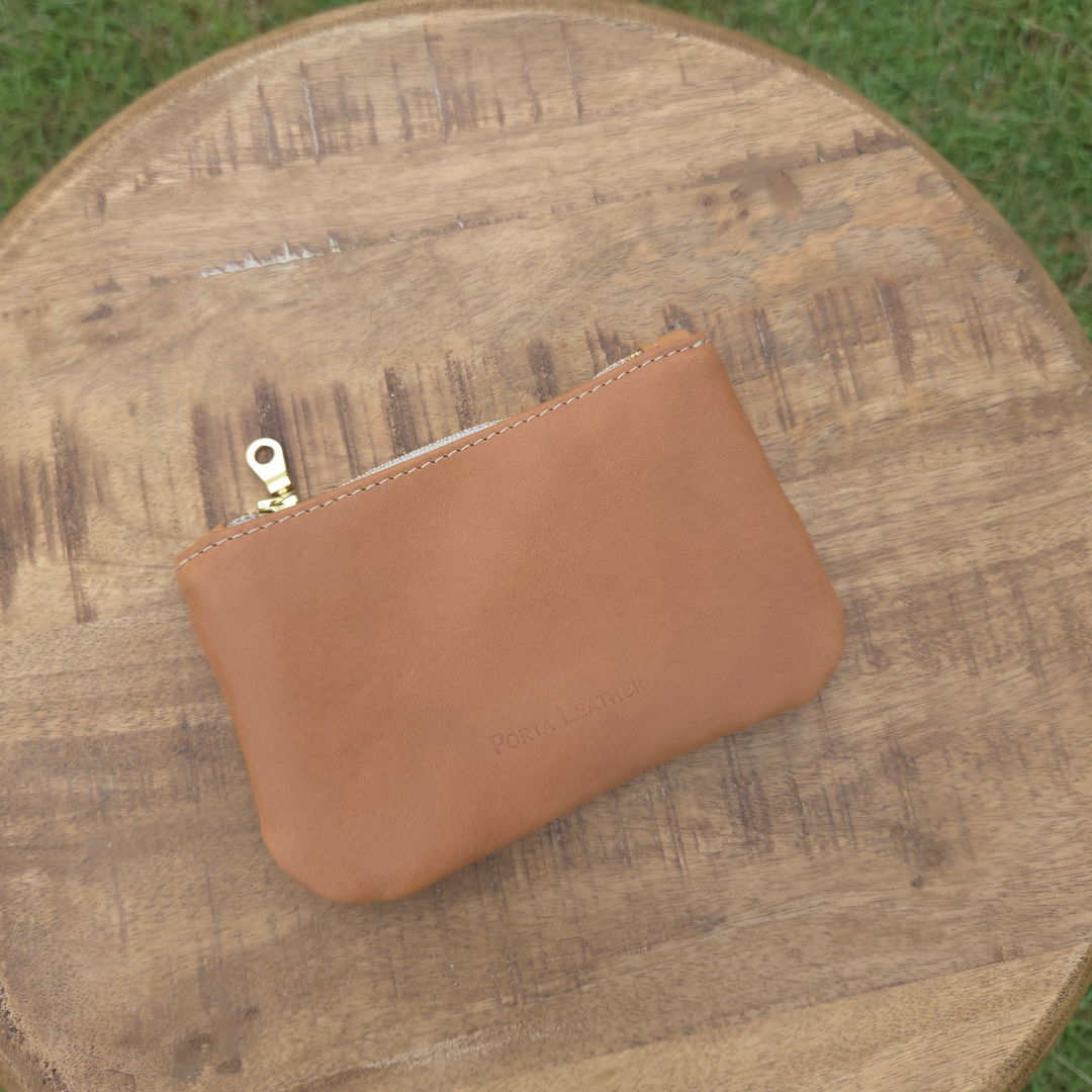 Porta Leather tan mini pouch placed on a stool