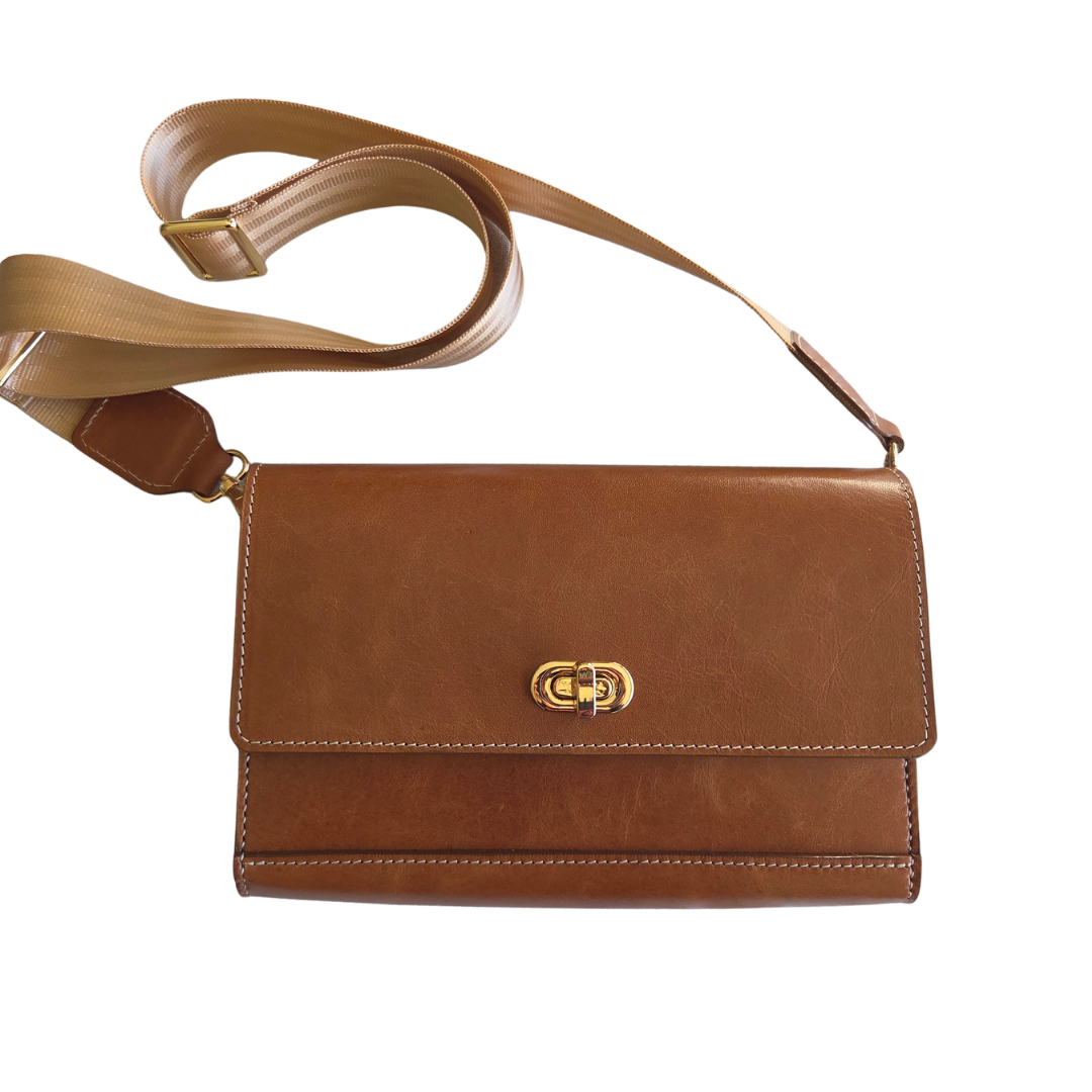 Porta Leather tan Jenna Bag with a gold clasp on a white background