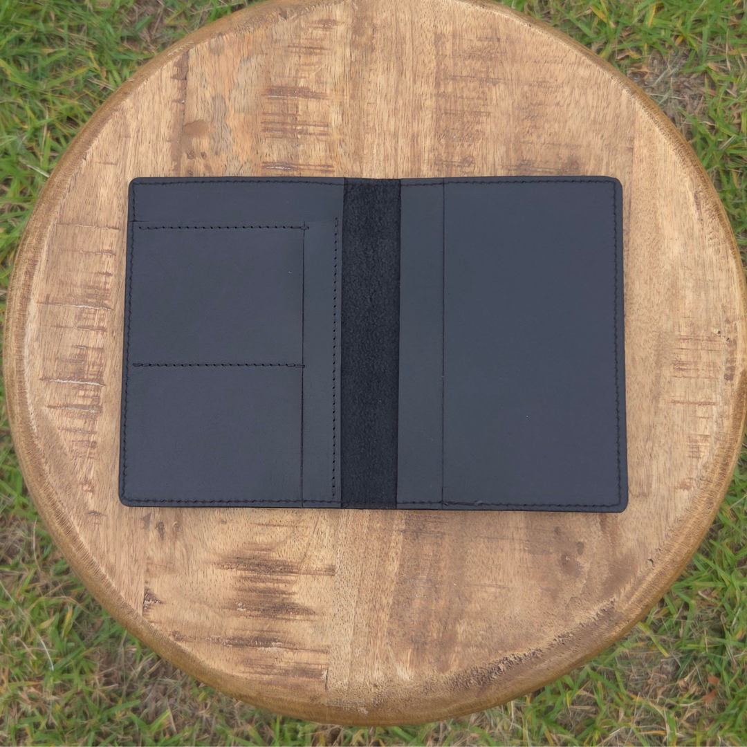 Black Porta Leather Passport Wallet on a wooden stool outdoors. Photo shows the inside view