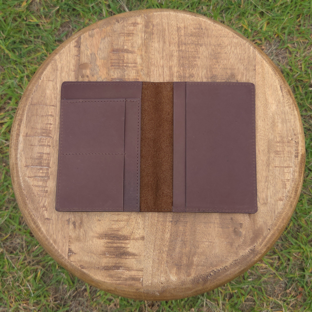 Brown Porta Leather Passport Wallet on a wooden stool outdoors. Photo shows the inside view